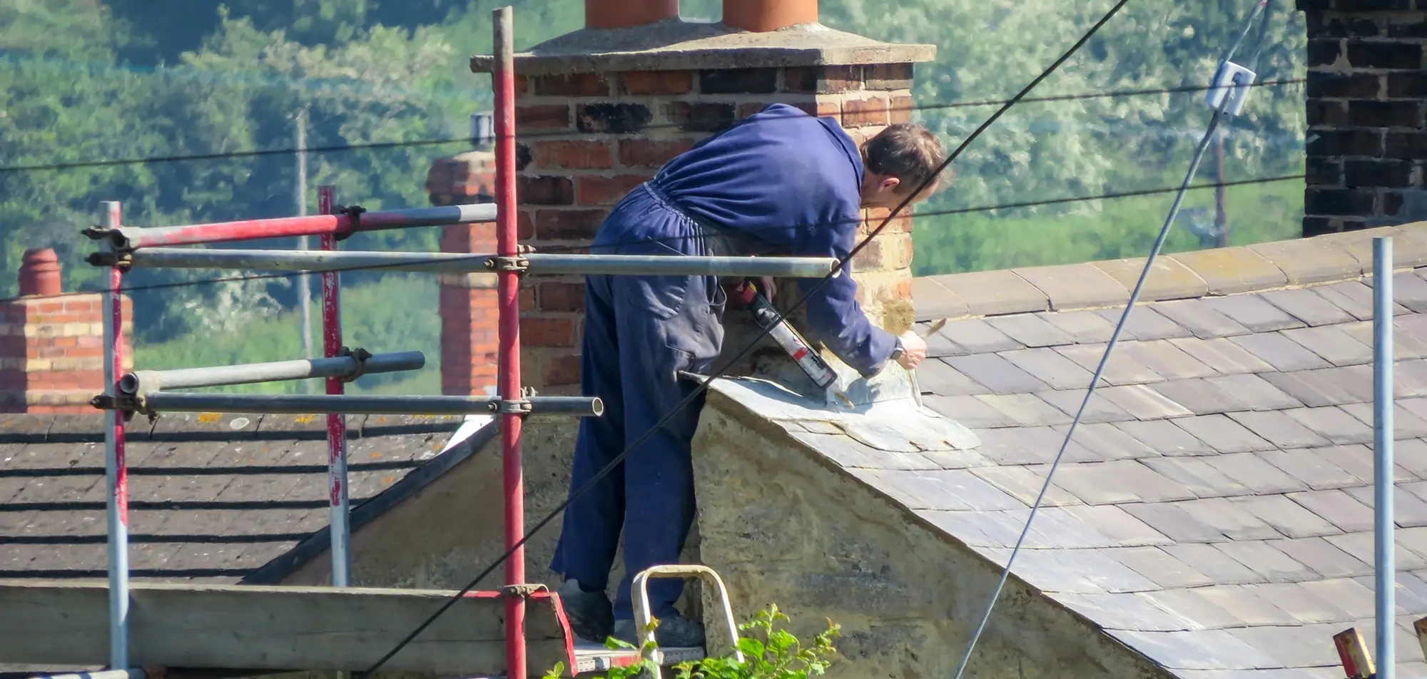 Technician repairing chimney flashing and exterior masonry