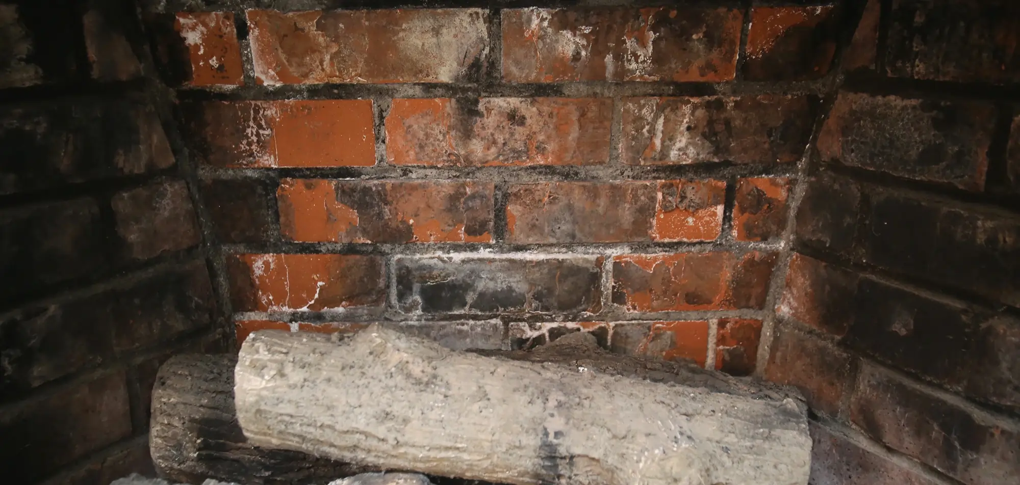 Damaged brick firebox requiring professional fireplace repair